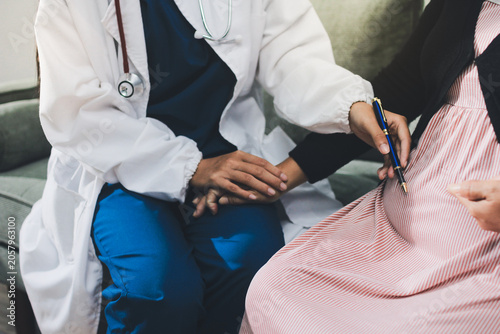 Fotografía Pregnant woman having her belly examined by a doctor with a stethoscope in a cli