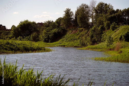 A scenic view of the river. Selected focus.The banks of a quiet river in summer are a great place for relaxation, fishing, finding peace of mind, and rejuvenation. Kamenka River in Suzdal, Vladimir Re