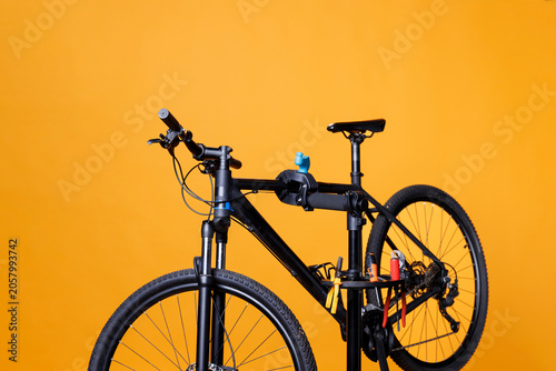 Quadro su tela View of bicycle on repair-stand surrounded by specialized equipment outside for maintenance and repair