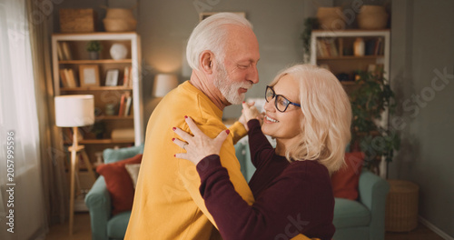 Fotografía An elderly couple enjoys dancing together in their living room