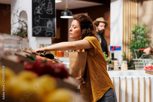 Konstfotografi Healthy living woman in zero waste shop looking to buy vegetables produced in ecofriendly farm