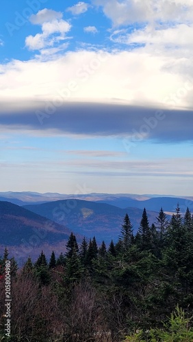 High angle scenic view of blue mountain ridges and pine forest under a cloudy sky