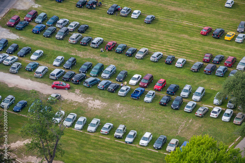 Rows of Parked Cars Viewed from Above - Elevated view of numerous parked vehicles arranged in rows across an open parking area.