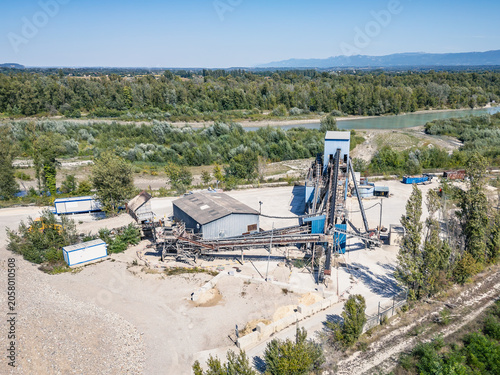 Aerial view of aggregate processing plant with conveyor systems, industrial machinery and mineral processing infrastructure operating within a quarry extraction site in Southern France