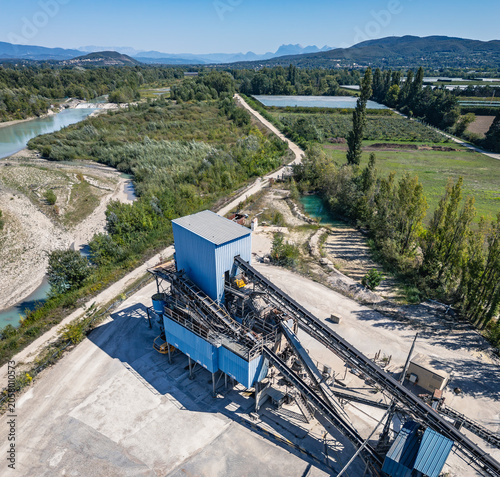Aerial view of aggregate processing plant with conveyor systems, industrial machinery and mineral processing infrastructure operating within a quarry extraction site in Southern France