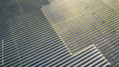 Top down aerial view of solar photovoltaic panels forming geometric pattern at renewable energy farm