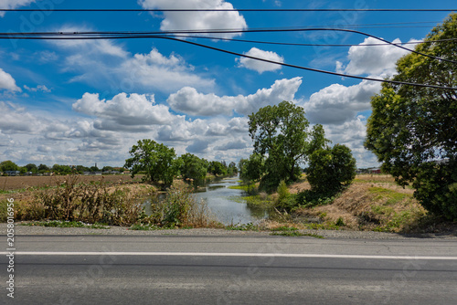 Fotografie Rural slough running alongside a paved road
