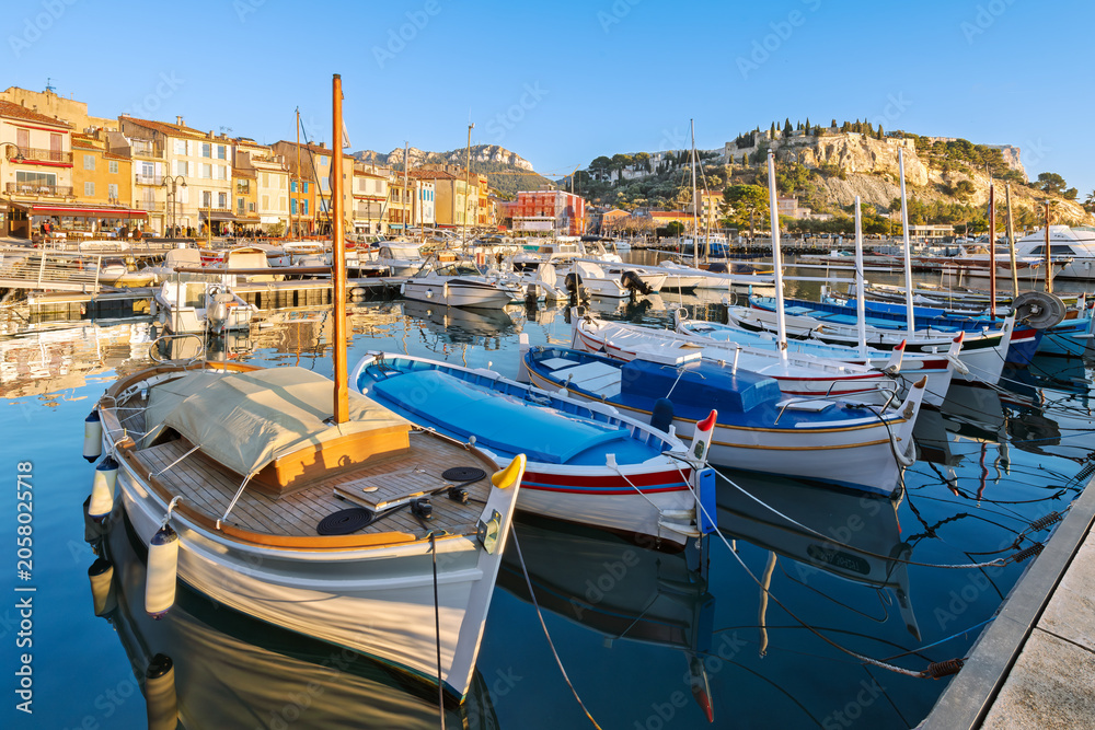 Obraz premium The charming French Riviera, seaside town of Cassis, France, with the medieval castle rising above the colorful old town and marina at dusk.