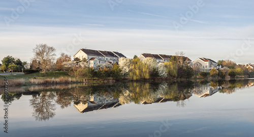 Foto Ashburn Village townhomes reflected in still lake water under blue sky