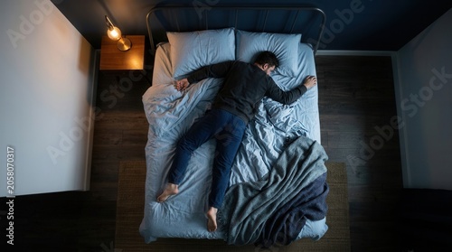 Man Sleeping Soundly In His Bed With Cozy Blanket Overhead View