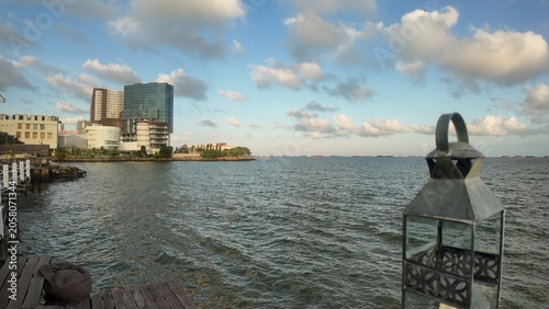Photo of a seaside or beach view with blue sky and surrounding buildings