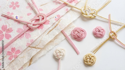 Elegant Japanese Mizuhiki knots and cherry blossom paper for gift wrapping, symbolizing good luck and celebration