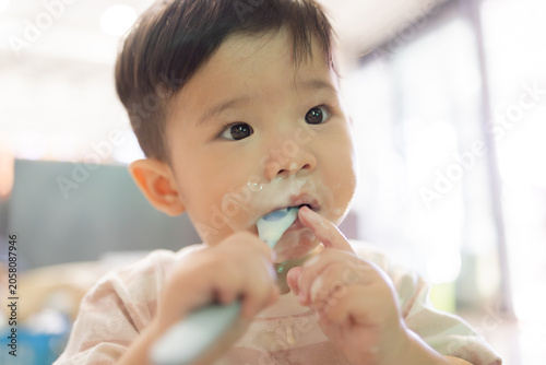 
Little child brushes teeth with soft toothbrush. Gentle, curious eyes look at camera. Fingers hold brush with care. Soft pink shirt adds warmth to scene. Ideal for parenting, dental hygiene
