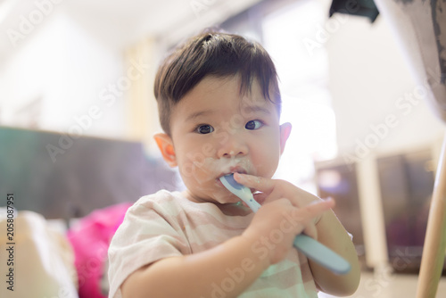 
Little child brushes teeth with soft toothbrush. Gentle, curious eyes look at camera. Fingers hold brush with care. Soft pink shirt adds warmth to scene. Ideal for parenting, dental hygiene
