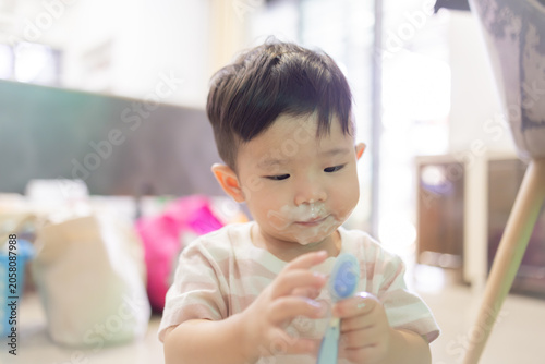 
Little child brushes teeth with soft toothbrush. Gentle, curious eyes look at camera. Fingers hold brush with care. Soft pink shirt adds warmth to scene. Ideal for parenting, dental hygiene
