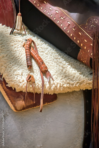 Foto Close up of a leather riding crop resting on a sheepskin saddle cover with traditional horse tack during an equestrian event