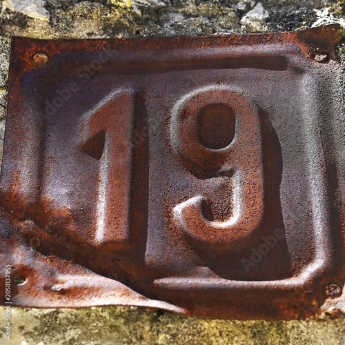 Rusty Vintage Metal House Number 19 Plate on Stone Wall, Croatia