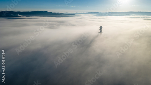 Картината върху платно Quiet plateau scenery of viewing tower on hilltop amid sea of fog during sunrise