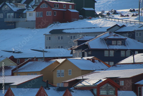 Longyearbyen town panorama in Svalbard, Norway. Remote arctic settlement with colorful houses, traditional wooden architecture, industrial heritage under winter snow and majestic polar mountains.
