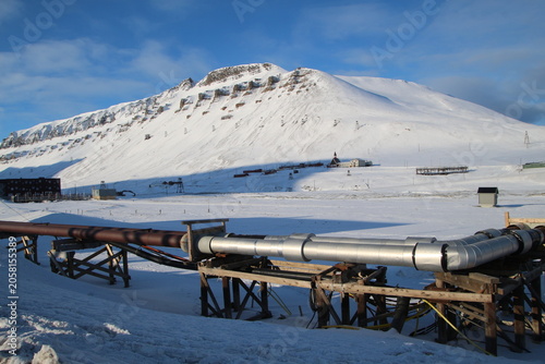 Longyearbyen town panorama in Svalbard, Norway. Remote arctic settlement with colorful houses, traditional wooden architecture, industrial heritage under winter snow and majestic polar mountains.