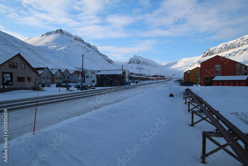 Longyearbyen town panorama in Svalbard, Norway. Remote arctic settlement with colorful houses, traditional wooden architecture, industrial heritage under winter snow and majestic polar mountains.