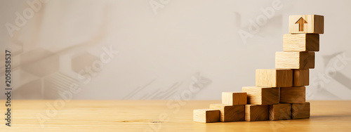 Wooden blocks stacked as stairs with arrow pointing up, representing progress.