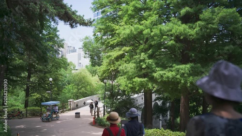 Peaceful afternoon landscape in Seoul Olympic Park, South Korea, featuring a lush green walking path and a bridge