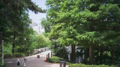 Peaceful afternoon landscape in Seoul Olympic Park, South Korea, featuring a lush green walking path and a bridge
