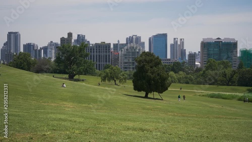 Panoramic landscape view of Olympic Park in Seoul, with a green meadow and city skyline in the background