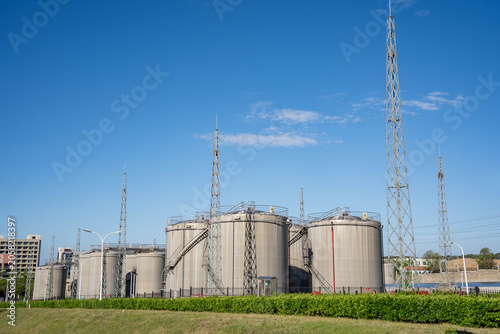 Industrial Storage Tanks and Lightning Protection Towers Under Clear Sky
