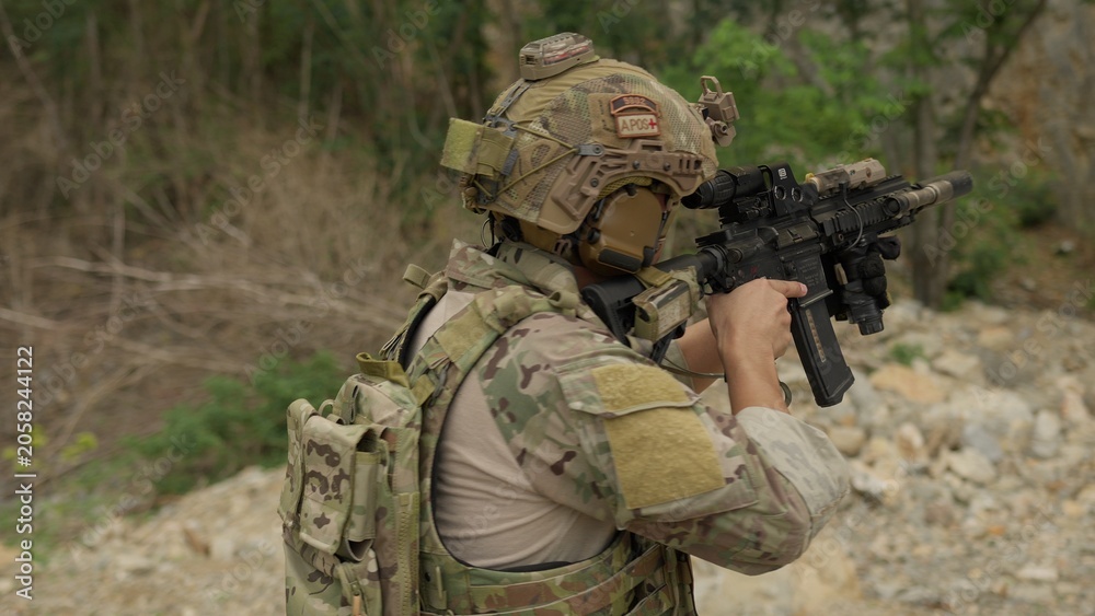 Fototapeta premium A special forces soldier aims his rifle during a tactical training exercise in a rugged outdoor environment, demonstrating precision and combat readiness.