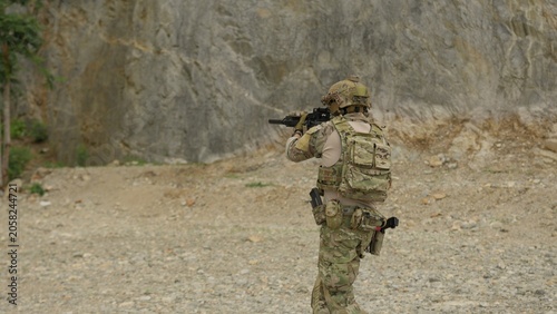Принти на полотні A special forces soldier aims his assault rifle during a tactical training exercise in a rocky, outdoor environment, practicing marksmanship and combat readiness