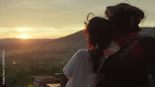 Foto A mother and daughter watch the sunset over mountains from a viewpoint, sharing a quiet moment of family bonding and appreciating the tranquil scenic view