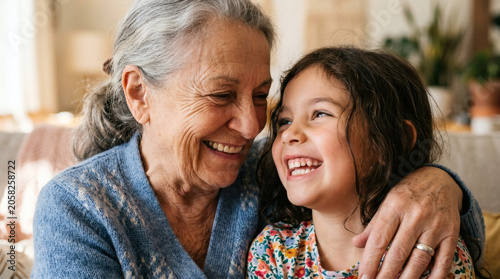 Grandmother hugging smiling granddaughter at home