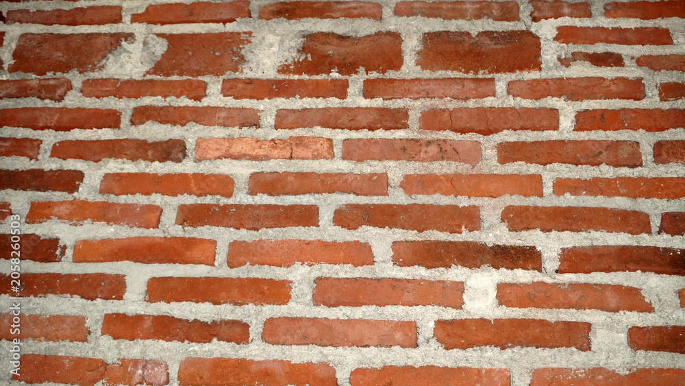 Naklejka premium Classic red brick wall with white mortar joints.