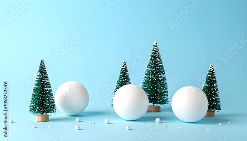 Miniature winter scene with snow-covered trees and snowballs on a light blue background