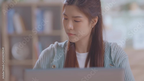 Young asian professional woman working on her laptop in a modern home office, focused on tasks and demonstrating productivity in a corporate environment. Smart freelancer working.