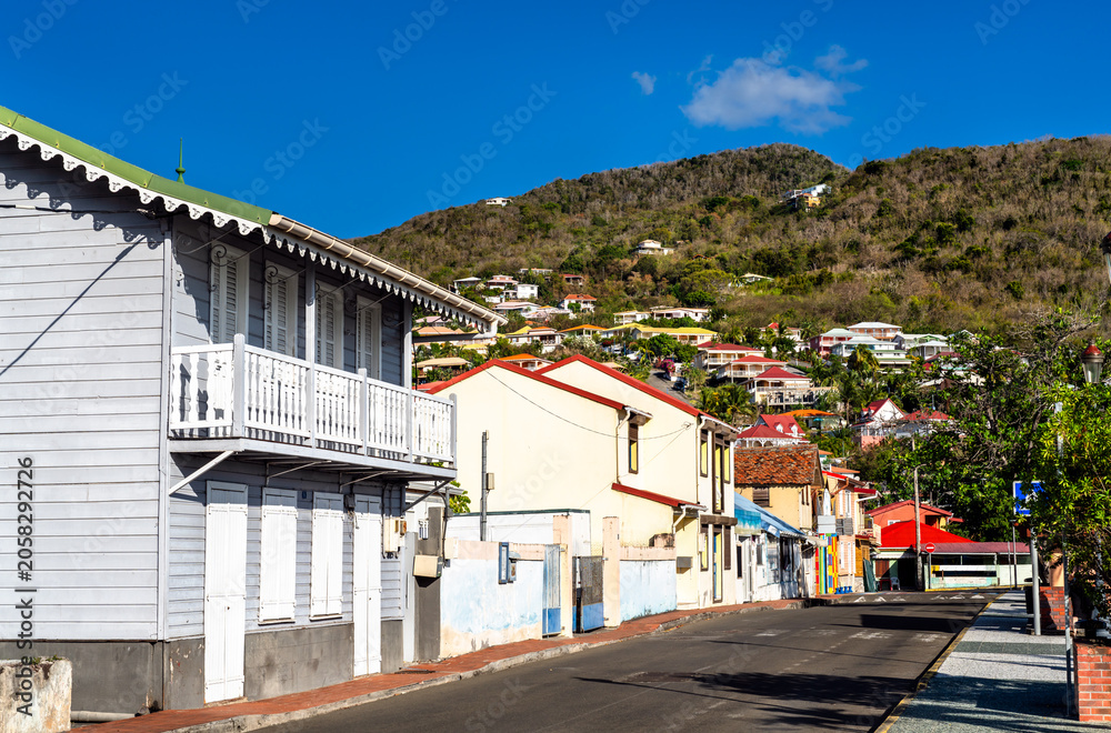 Fototapeta premium View of colorful creole architecture and traditional wooden houses on a sunny street in the village of Les Anses d'Arlet, Martinique, Caribbean France