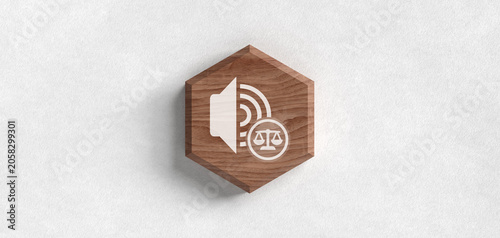A wooden hexagon features a white icon combining a speaker and a scales of justice, symbolizing media law, legal communication, freedom of speech, and auditory regulation.