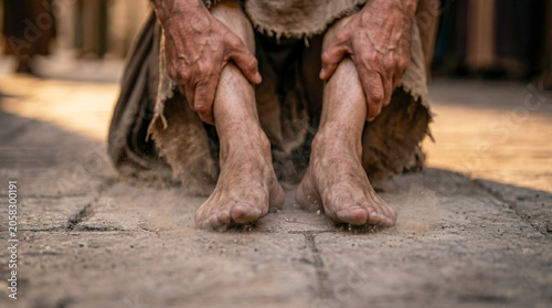 Apostle Peter helping crippled man at temple gate. Historical biblical scene showing miracle of healing described in Acts 3. Religious reenactment of ancient faith and divine grace