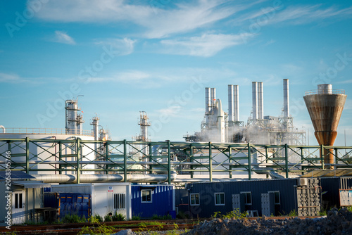 Картината върху платно Industrial plant refinery factory pipeline smokestack steam blue sky infrastruct