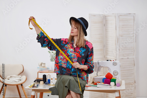 Fashion designer measuring fabric in creative sewing studio