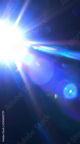 Bright blue light beams with lens flare on dark background