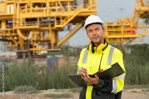 Fotografía Industrial engineer holding a check list clipboard and walkie-talkie at an offshore energy platform