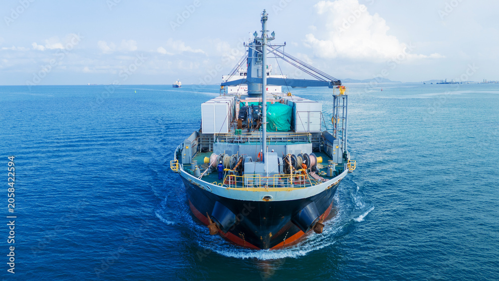 Fototapeta premium argo ship navigating through the deep blue ocean, carrying heavy equipment and containers on deck, representing global maritime logistics and international trade.