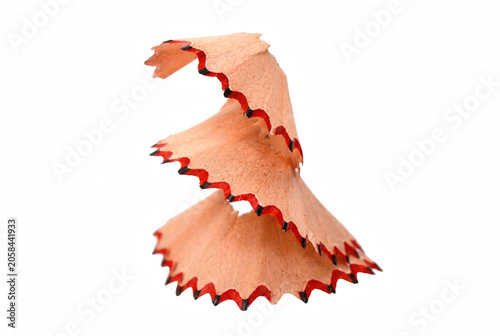 Curved wooden pencil shaving with scalloped red edges