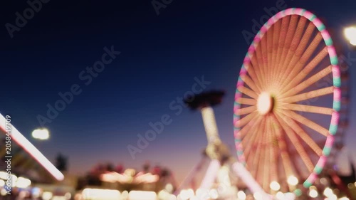Blurred Carnival Lights With Colorful Bokeh At Amusement Park At Night