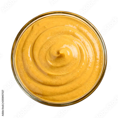 Delicious yellow mustard condiment in a glass bowl on white background