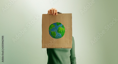 Fotografija arth Day expression with person holding cardboard sign and hand painted globe, e