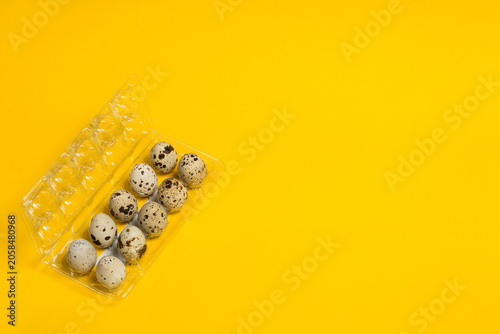 Small quail eggs on a yellow background, healthy food and diet
